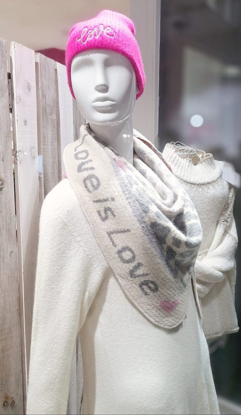 Mannequin mit pinker Mütze und Schal mit dem Aufdruck „Love is Love“.