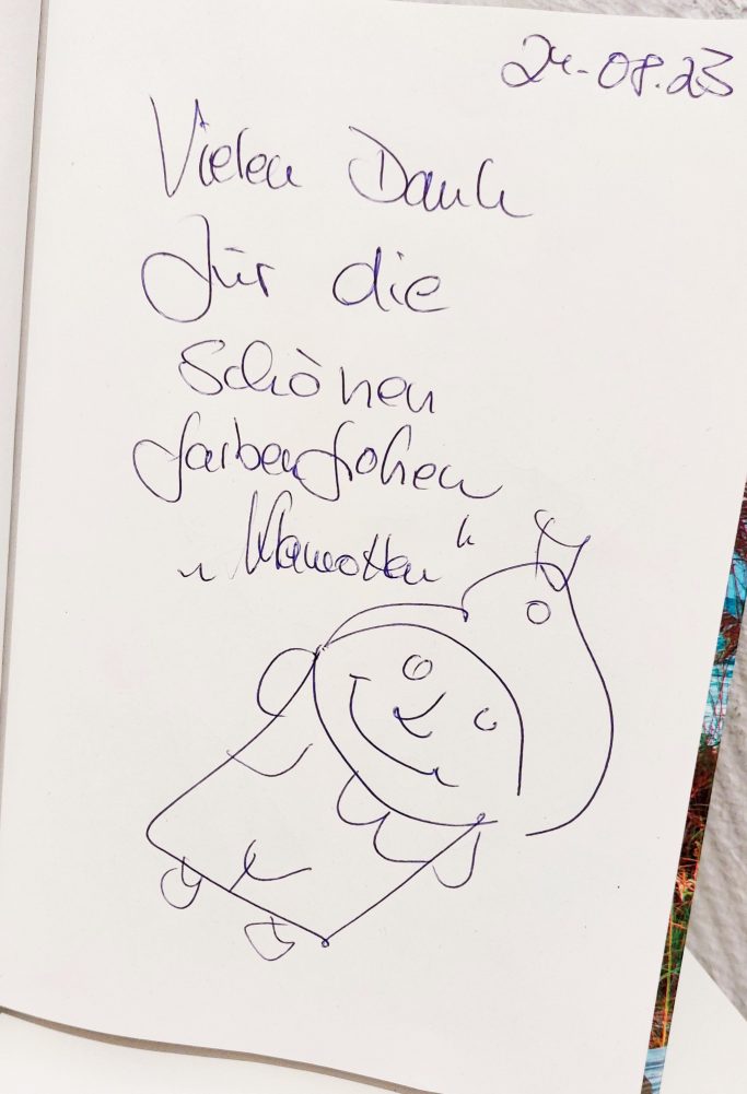 Eine gezeichnete Figur mit einer Mütze, umgeben von handschriftlichem Text.