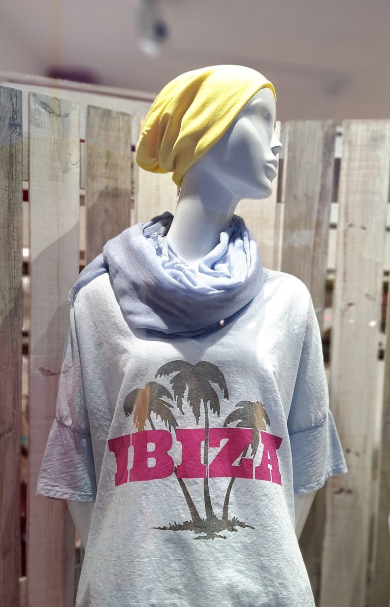 Mannequin in T-Shirt mit "IBIZA"-Aufdruck, gelbe Mütze und blauer Schal.