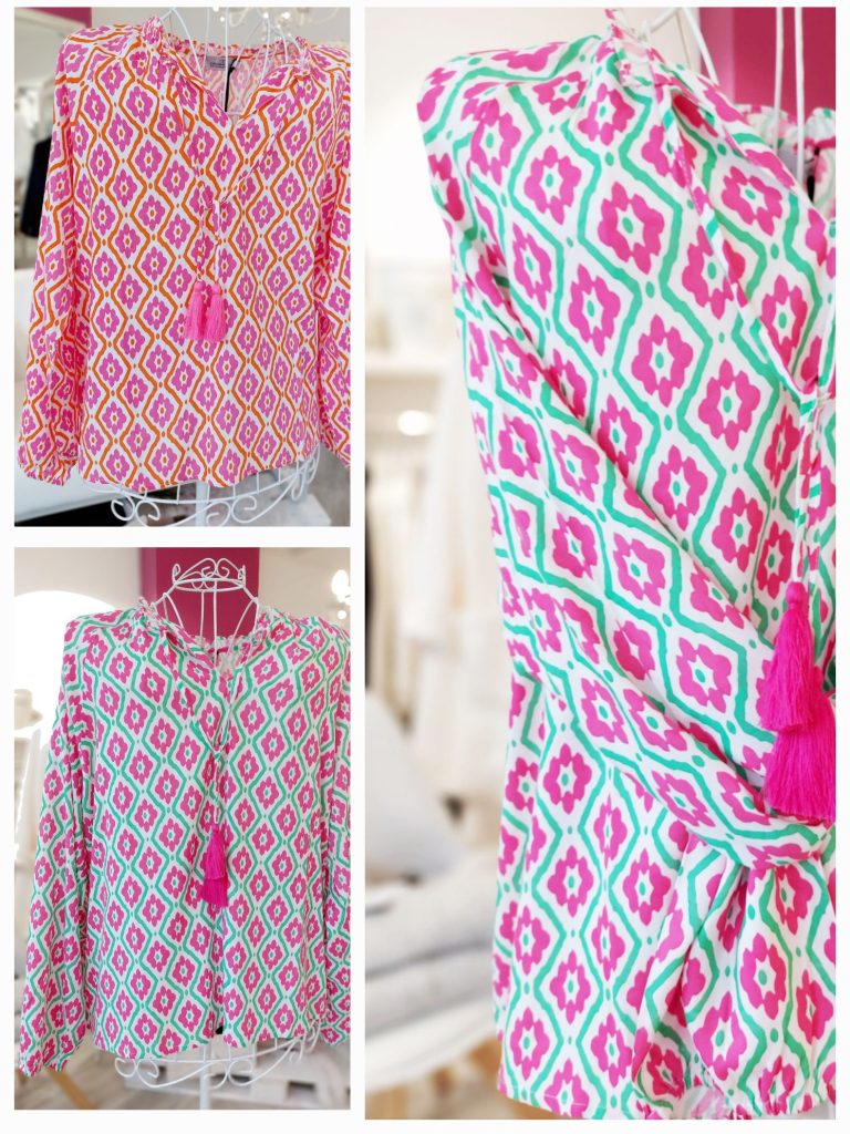Bunte Bluse mit geometrischem Muster und Fransen-Applikation in Pink und Grün.
