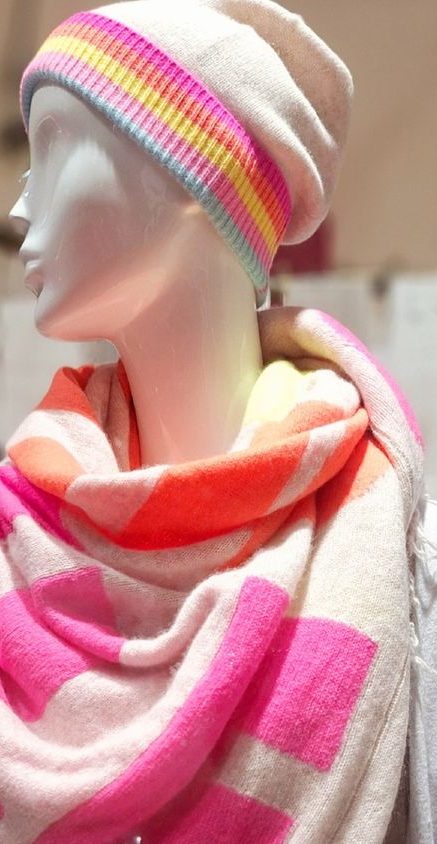 Mannequin mit einer bunten Kaschmir Mütze und einem gestreiften, farbenfrohen Schal.