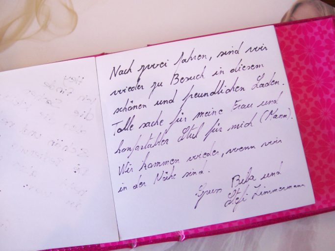 Handschriftlicher Text in einem Notizbuch mit rosa Einband und dekorativer Innenseite.