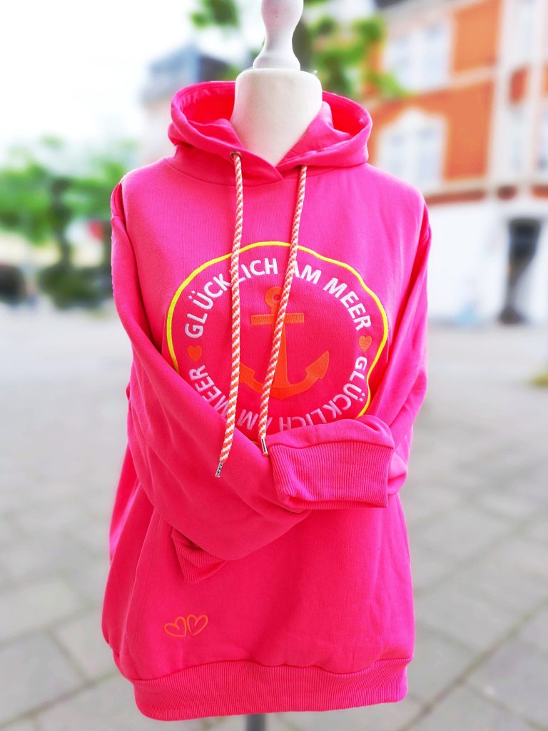 Rosa Kapuzenpullover mit einem Rundlogo und Schriftzug auf der Vorderseite.