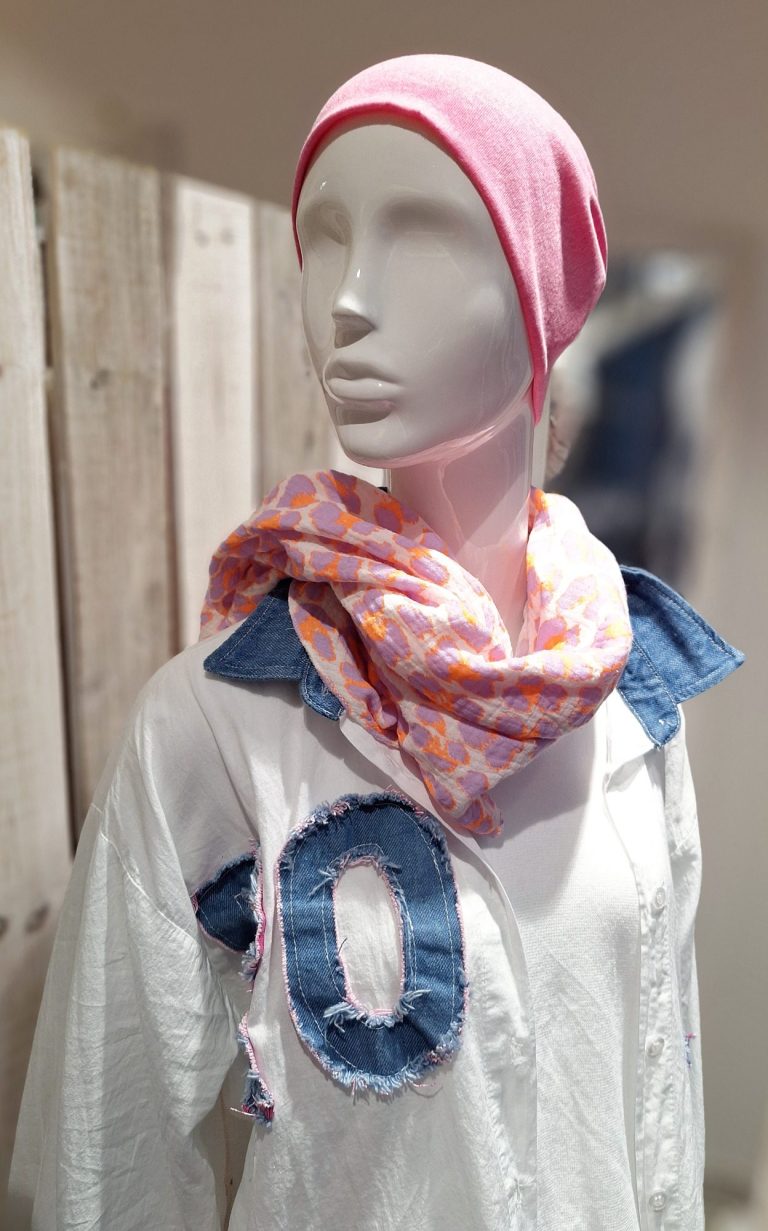 Mannequin trägt ein weißes Hemd mit Denim-Applikation und einen bunten Schal.