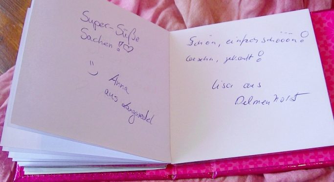 Offenes Buch mit handgeschriebenen Nachrichten und persönlichen Notizen auf leeren Seiten.