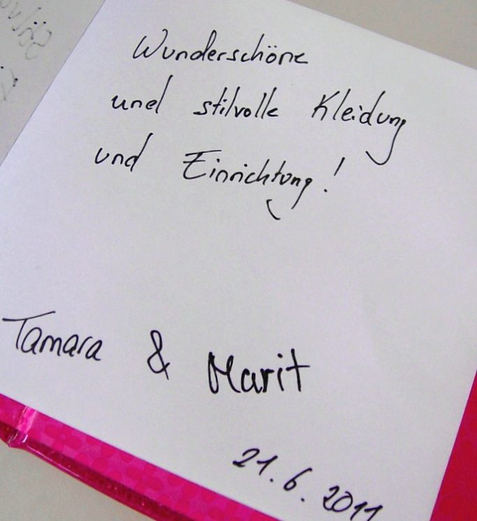 Handschriftlicher Text auf einem Blatt mit den Worten: "Wunderschöne und stilvolle Kleidung und Einrichtung!"