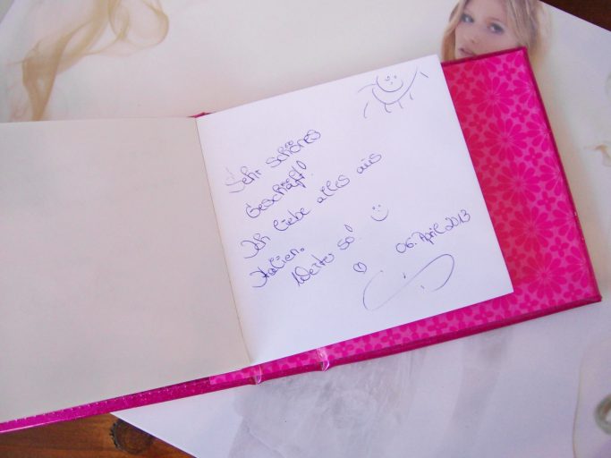Eine aufgeklappte, dekorative Notizbuchseite mit handgeschriebenem Text.