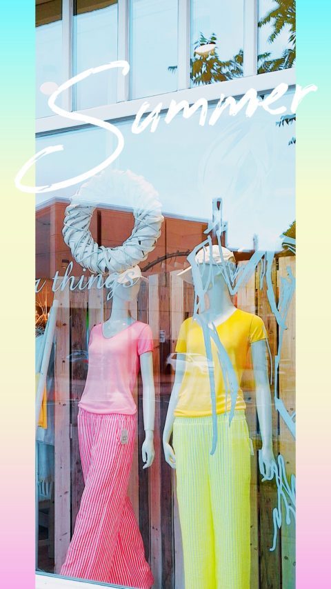 Zwei Schaufensterpuppen in farbigen Sommeroutfits, beschriftet mit "Summer".